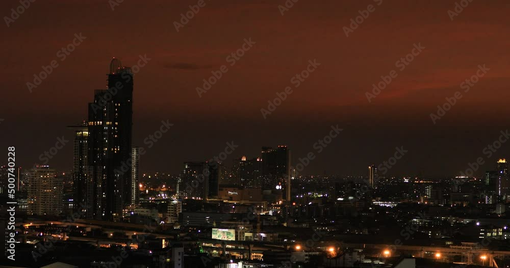 High-angle 4K video that sees condominiums of various sizes encircling the city center, business district, and blurry lights and passing cars during the evening twilight sky. High-angle 4K video that sees condominiums of various sizes encircling the city center, business district, and blurry lights and passing cars during the evening twilight sky.