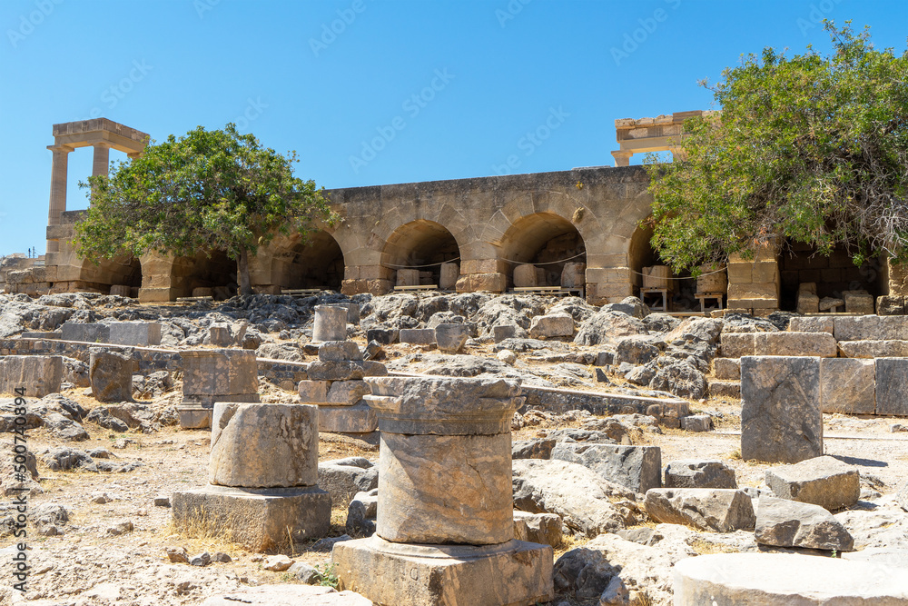 View of summit of Acropolis and ruins of Lindos, Columns of  Hellenistic stoa. Archaeological site, a fishing village and a former municipality on island of Rhodes, in the Dodecanese, Greece