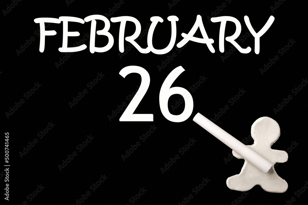 A small white plasticine man writing the date 26 February on a black board. Business concept. Education concept. A small white plasticine man writing the date 26 February on a black board. Business concept. Education concept.