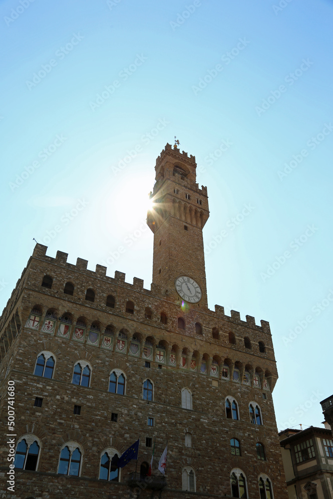 Obraz premium OLD PALACE called Palazzo Vecchio with the high tower called Torre di Arnolfo di Cambio in Florence in Italy and the sun coming out from behind