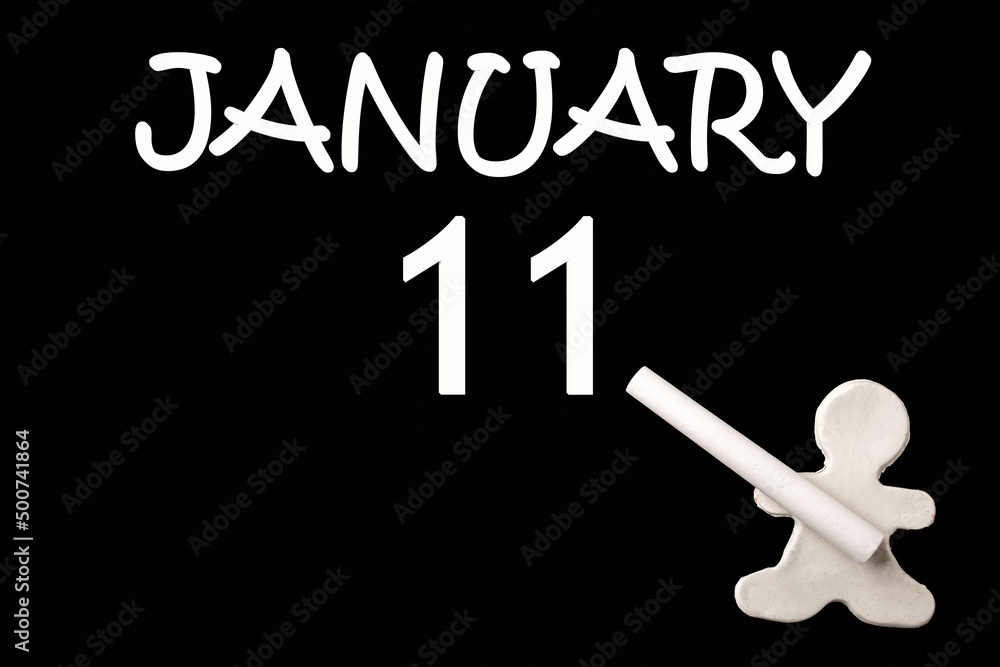 A small white plasticine man writing the date 11 January on a black board. Business concept. Education concept. A small white plasticine man writing the date 11 January on a black board. Business concept. Education concept.