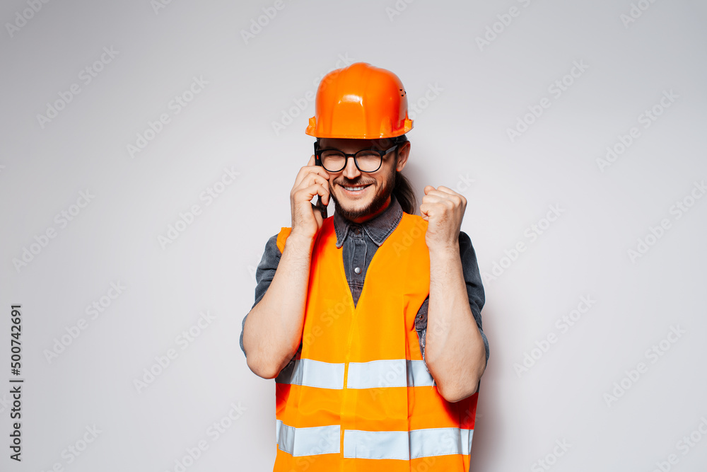 Yes! Portrait of happy engineer talking on smartphone, on white background. Yes! Portrait of happy engineer talking on smartphone, on white background.
