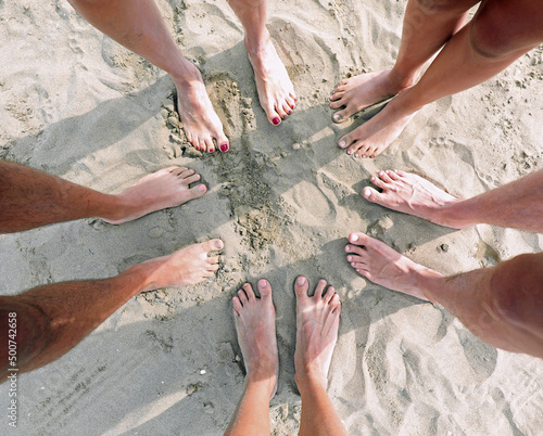 feet on the beach of a family with 5 people father mother and three children