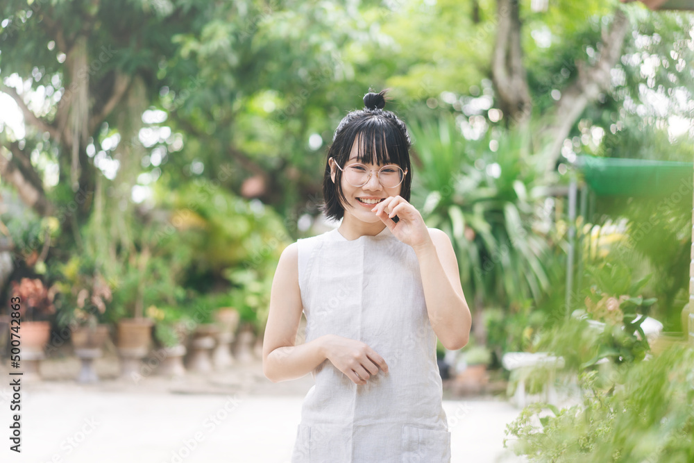 Portrait of young adult asian woman face wear eyeglasses and short hair stay at home in green garden yard on day Portrait of young adult asian woman face wear eyeglasses and short hair stay at home in green garden yard on day