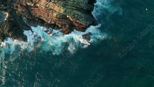 Aerial view of waves crashing on the rocks along the coast, Cornwall, United Kingdom. photo