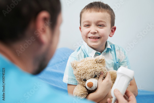 Joyful boy talking to the doctor in the office