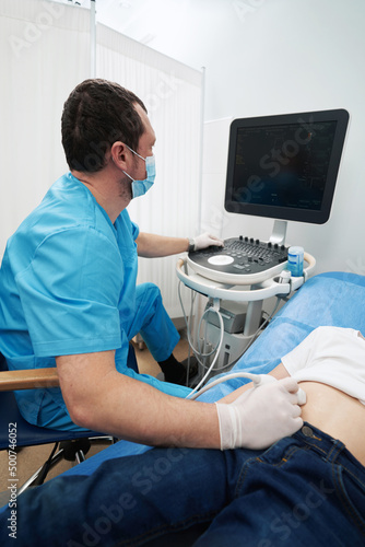 Medical worker carefully performing an abdominal ultrasound on child