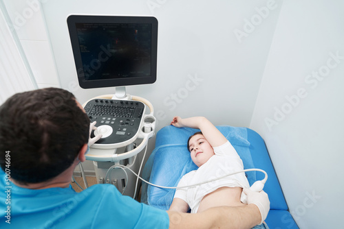 Caring health worker examining the result of kidney ultrasound on monitor