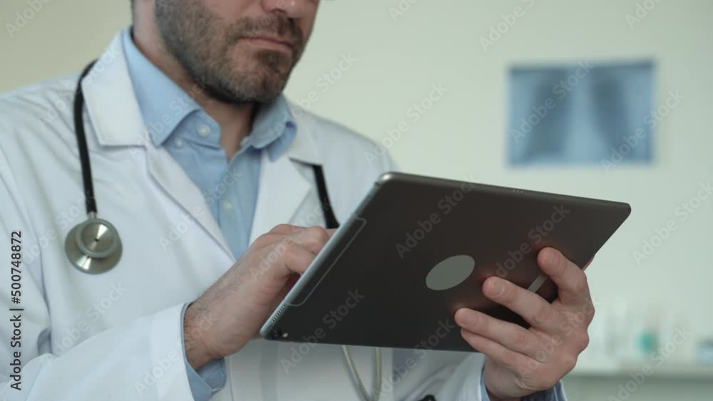 Close up view of male doctor hands using healthcare software application on tablet. Social network. Telemedicine, Remote. Healthcare services in pandemic concept. No face. 4k footage Close up view of male doctor hands using healthcare software application on tablet. Social network. Telemedicine, Remote. Healthcare services in pandemic concept. No face. 4k footage