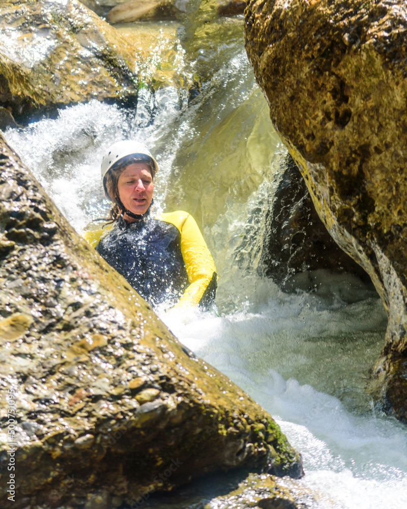 Adrenalin-Schub beim Canyoning in einer engen Felsrutsche mit Wasserfall Adrenalin-Schub beim Canyoning in einer engen Felsrutsche mit Wasserfall