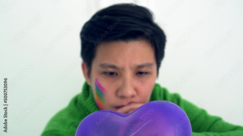LGBT tomboy lesbian woman abstract wonder about love holding purple heart balloon LGBT tomboy lesbian woman abstract wonder about love holding purple heart balloon
