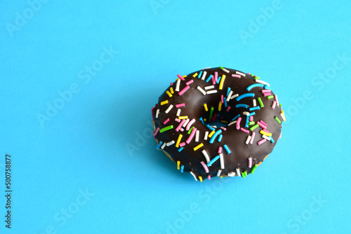 chocolate donut isolated on blue background, close-up