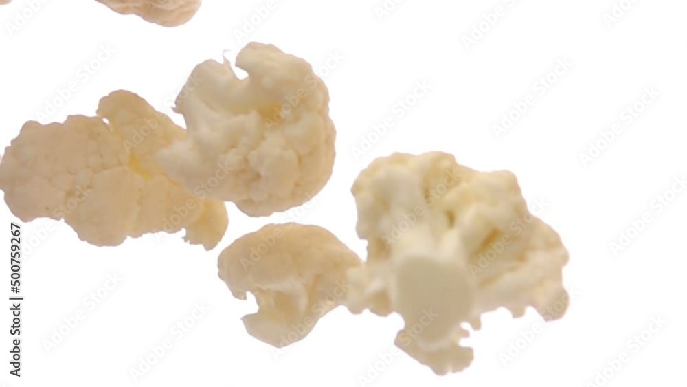 Close-up of ripe cauliflower pieces falling diagonally on the white background Close-up of ripe cauliflower pieces falling diagonally on the white background