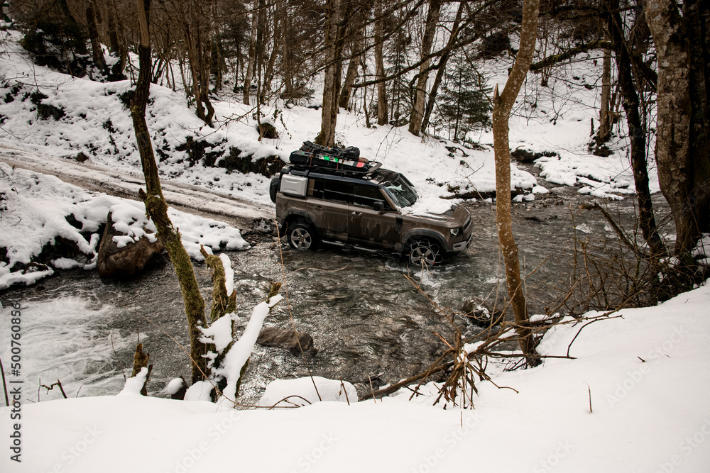 high angle view on off-road vehicle driving through a mountain river at winter high angle view on off-road vehicle driving through a mountain river at winter