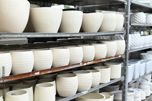 white ceramic pots for plants of various designs and sizes on display for sale in a gardener shop