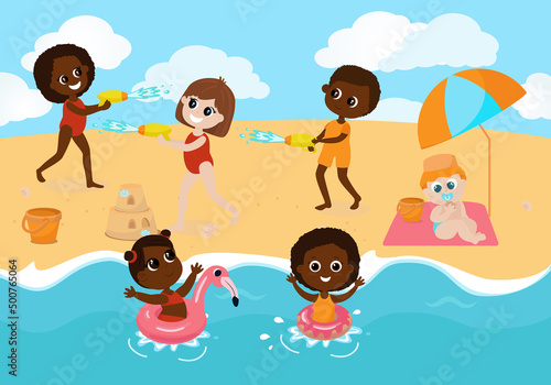 Children play on the beach,girls and boy had a water battle and sit under a sun umbrella. The boy inflates an inflatable ring, the baby sits on a blanket, the children swim in the sea.