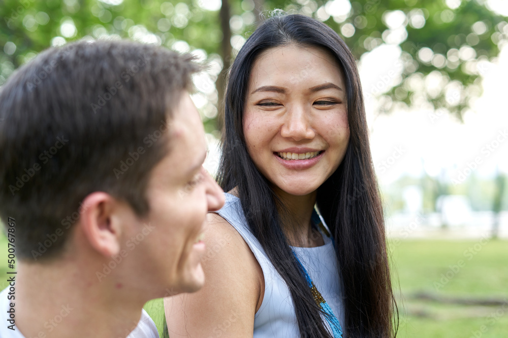 Smiling thai woman looking to his couple in a park Smiling thai woman looking to his couple in a park