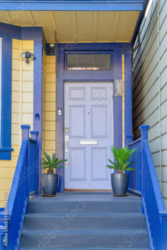 Exterior of a house with blue trims and yellow wood lap sidings at San Francisco, California
