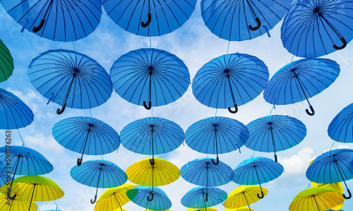 Decorative parasols hanging in sky bottom- up. Umbrella background. Street decoration