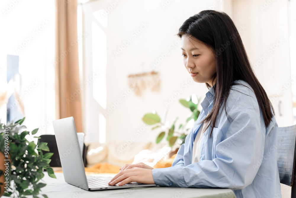 Portrait of young asian woman studying online or taking web course on computer at home, working on laptop from home office. The concept of distance education. Portrait of young asian woman studying online or taking web course on computer at home, working on laptop from home office. The concept of distance education.