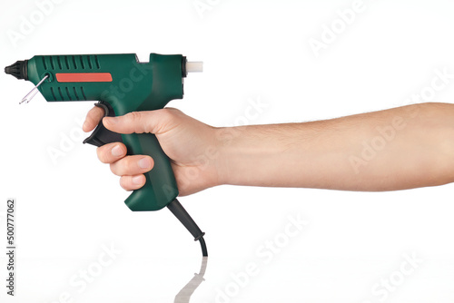 Electric hot glue gun in hand, isolated on white.