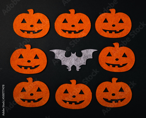 Frame of figures of orange pumpkins and bats on a black background. DIY Halloween decor.Holiday card.Halloween holiday concept.Place for copy.Place for text.Top view.