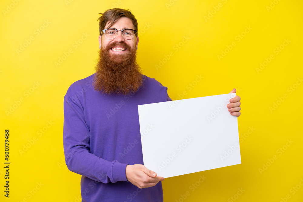 Redhead man with beard isolated on yellow background holding an empty placard with happy expression Redhead man with beard isolated on yellow background holding an empty placard with happy expression