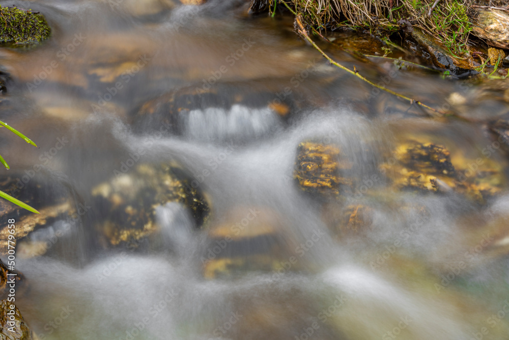 Fresh color clean water in mountains creek with color stones Fresh color clean water in mountains creek with color stones