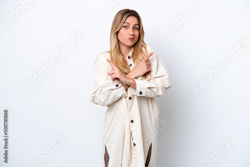 Young Uruguayan woman isolated on white background pointing to the laterals having doubts