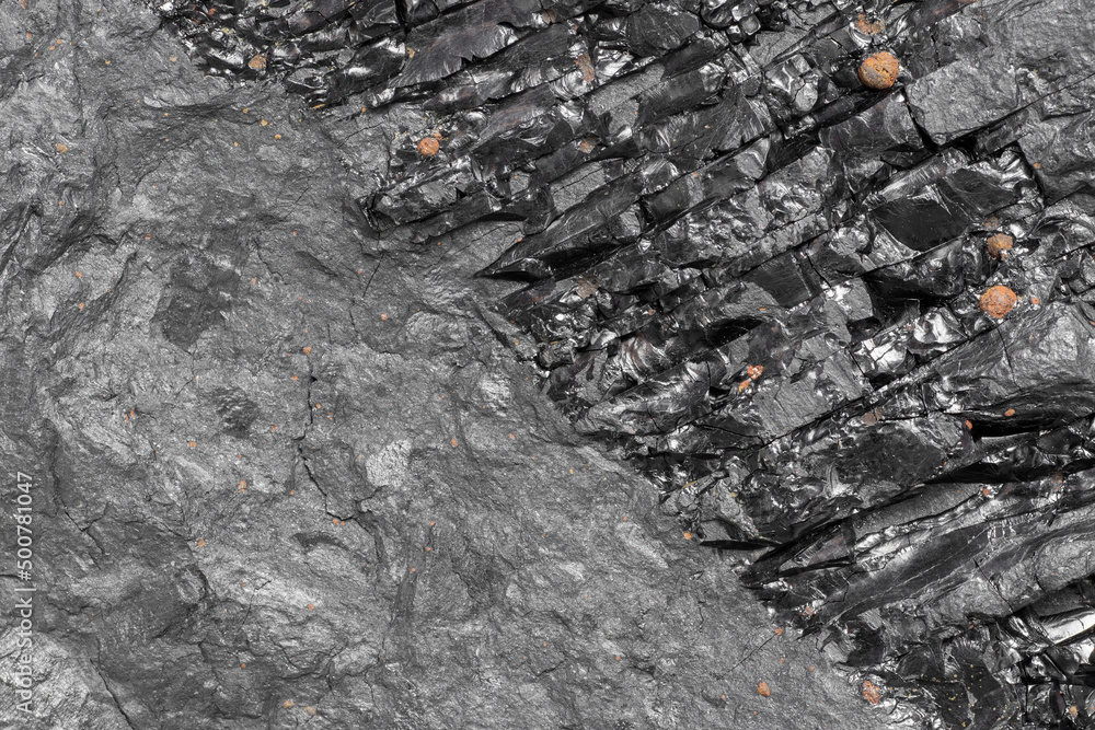 Closeup of black coal rock cross-section texture. Unclean energy source