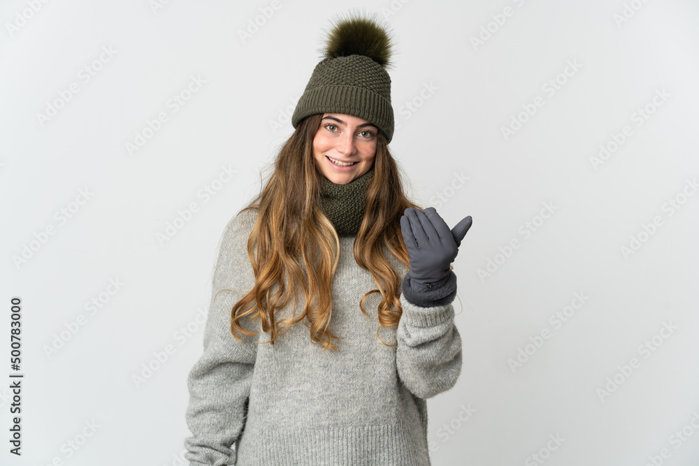 Young caucasian woman with winter hat isolated on white background inviting to come with hand. Happy that you came Young caucasian woman with winter hat isolated on white background inviting to come with hand. Happy that you came