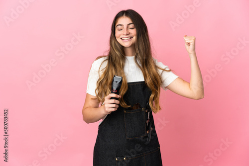 Young hairdresser woman isolated on pink background doing strong gesture