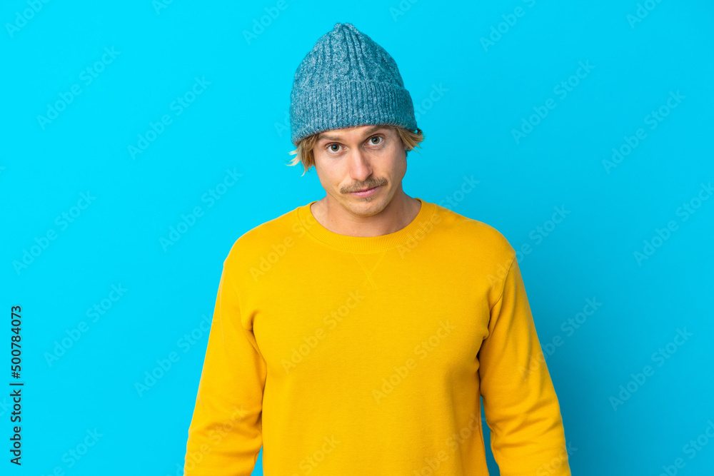Handsome blonde man isolated on blue background with sad expression Handsome blonde man isolated on blue background with sad expression