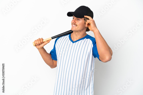 Young blonde man isolated on white background playing baseball