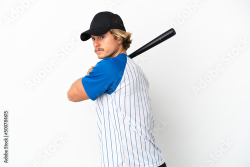 Young blonde man isolated on white background playing baseball