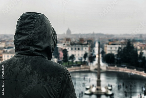 Encapuchado viendo Roma bajo la lluvia