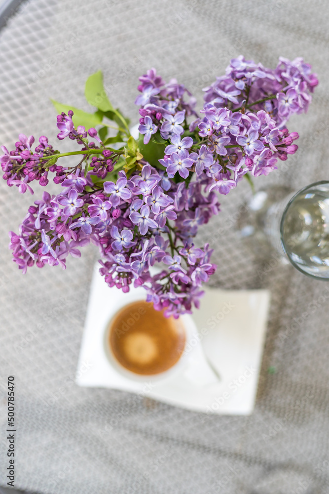Purple lilac flowers and a cup of coffee.Morninig, spring