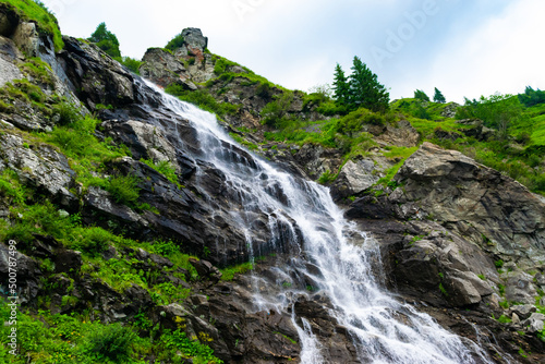 The Balea waterfall flow down the stone slope of the mountain. Waterfall location near Transfagarasan road. Romania.