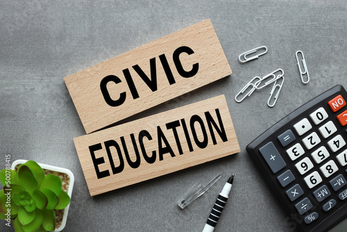 CIVIC EDUCATION text on wooden blocks on gray background near plant and calculator