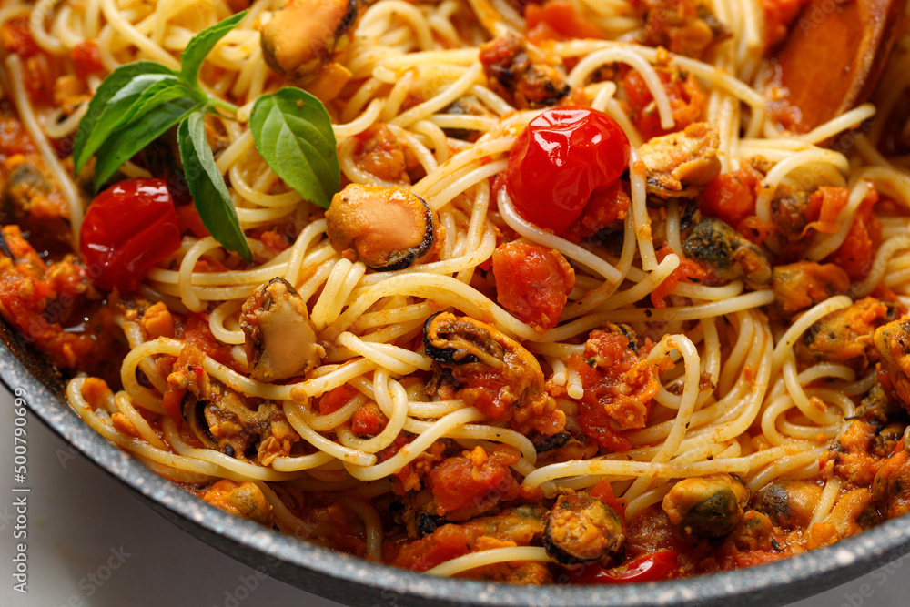 Seafood pasta with mussels, tomatoes, basil in frying pan. Close up. Seafood pasta with mussels, tomatoes, basil in frying pan. Close up.
