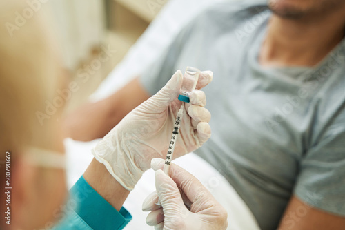 Physician filling a syringe with liquid medication
