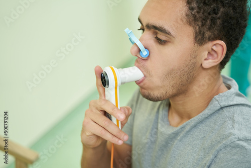 Patient checking his lung function with spirometer photo