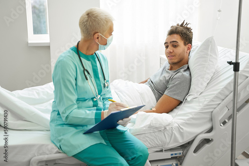 Male patient looking at doctor notes with interest
