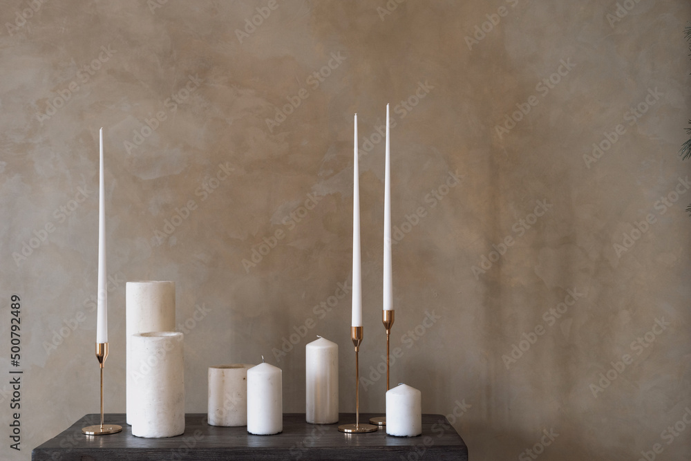 Set of white candles stand on wooden table Set of white candles stand on wooden table