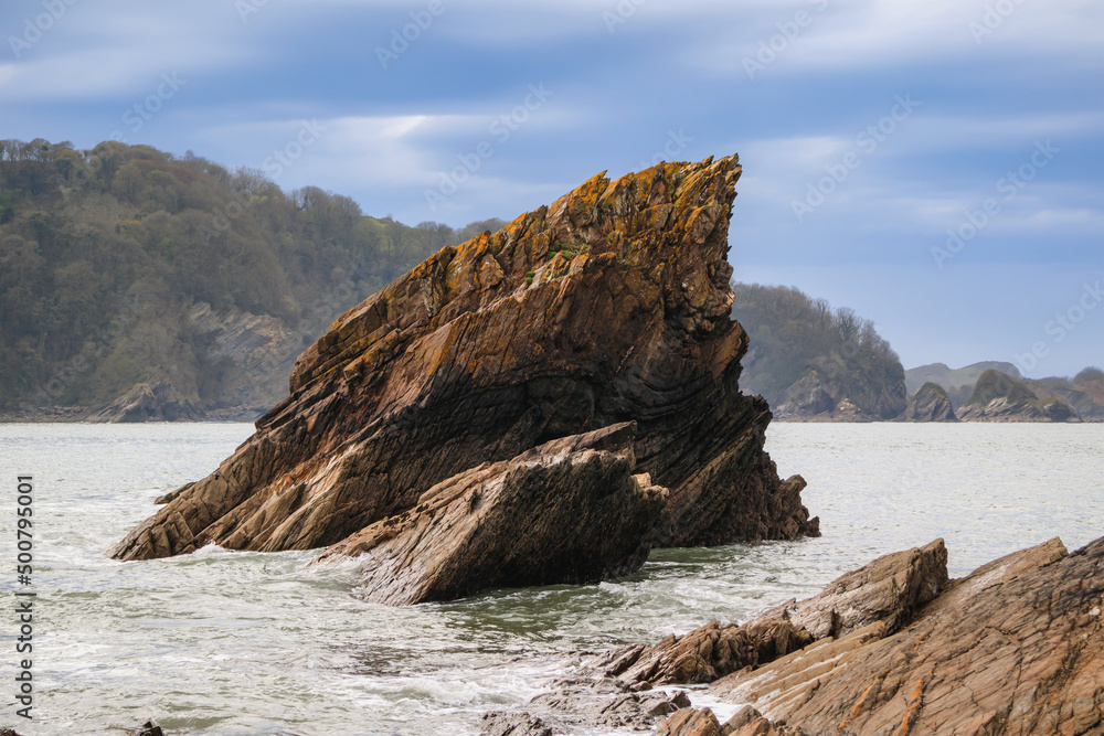 Cliff in the ocean. Ocean coast before the storm, cloudy sky Cliff in the ocean. Ocean coast before the storm, cloudy sky