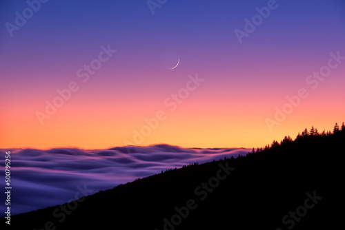 Earth shine, crescent moonrise at sunset over the Appalachian Mountains from Carvers Gap in Tennessee