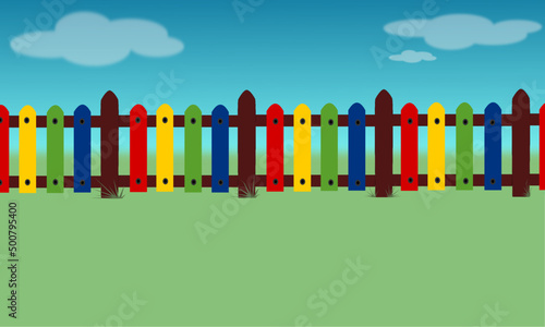 Colorful children's fence with blue sky and grass background