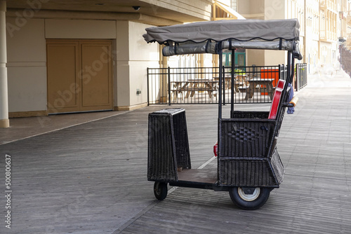 A famous wicker rolling chair is seen on the boardwalk in front of a casino building