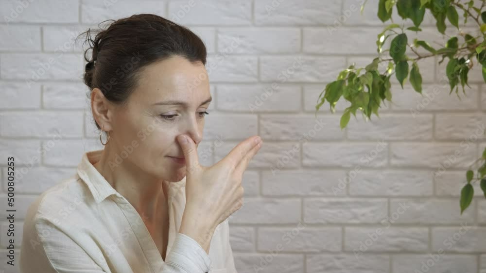 Woman calm nasal breathing. A happy woman test her nasal breathing in the room. Woman calm nasal breathing. A happy woman test her nasal breathing in the room.