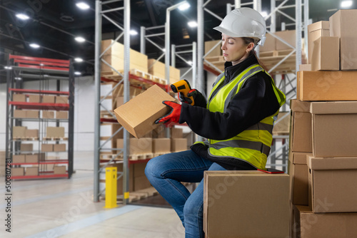 Storekeeper in supermarket. Girl with barcode scanner. Girl in warehouse of large store. Concept - delivery of goods from warehouse. Storekeeper at supermarket warehouse. Storekeeper Career
